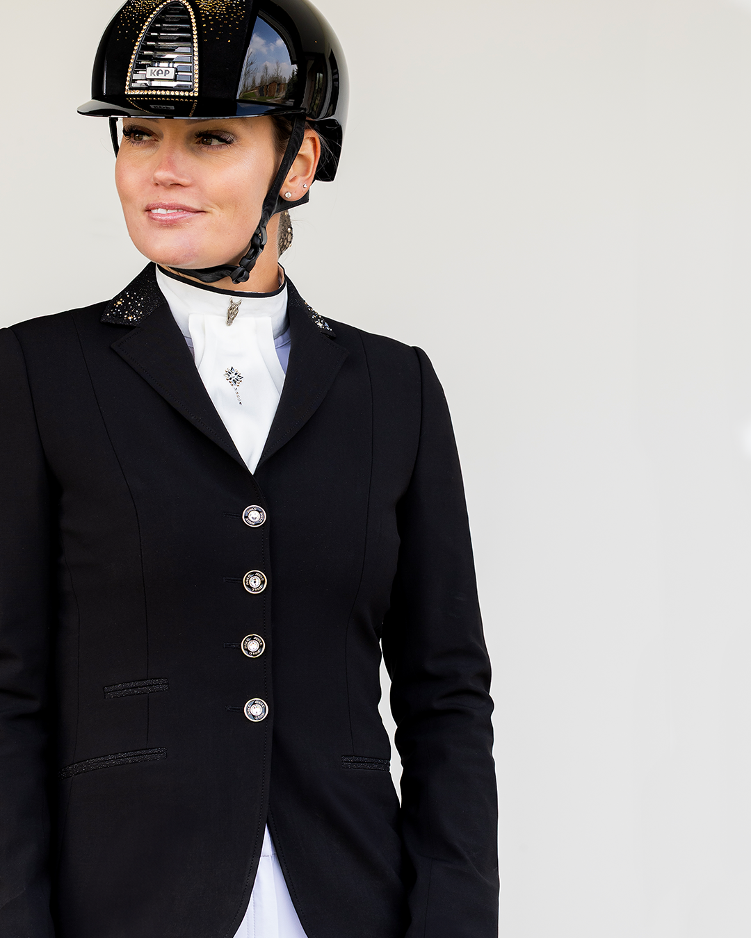 Detail of front of JuulC Women's show jacket in Black Stardust with glitter fabric accents and Swarovski details on the collar, worn by model