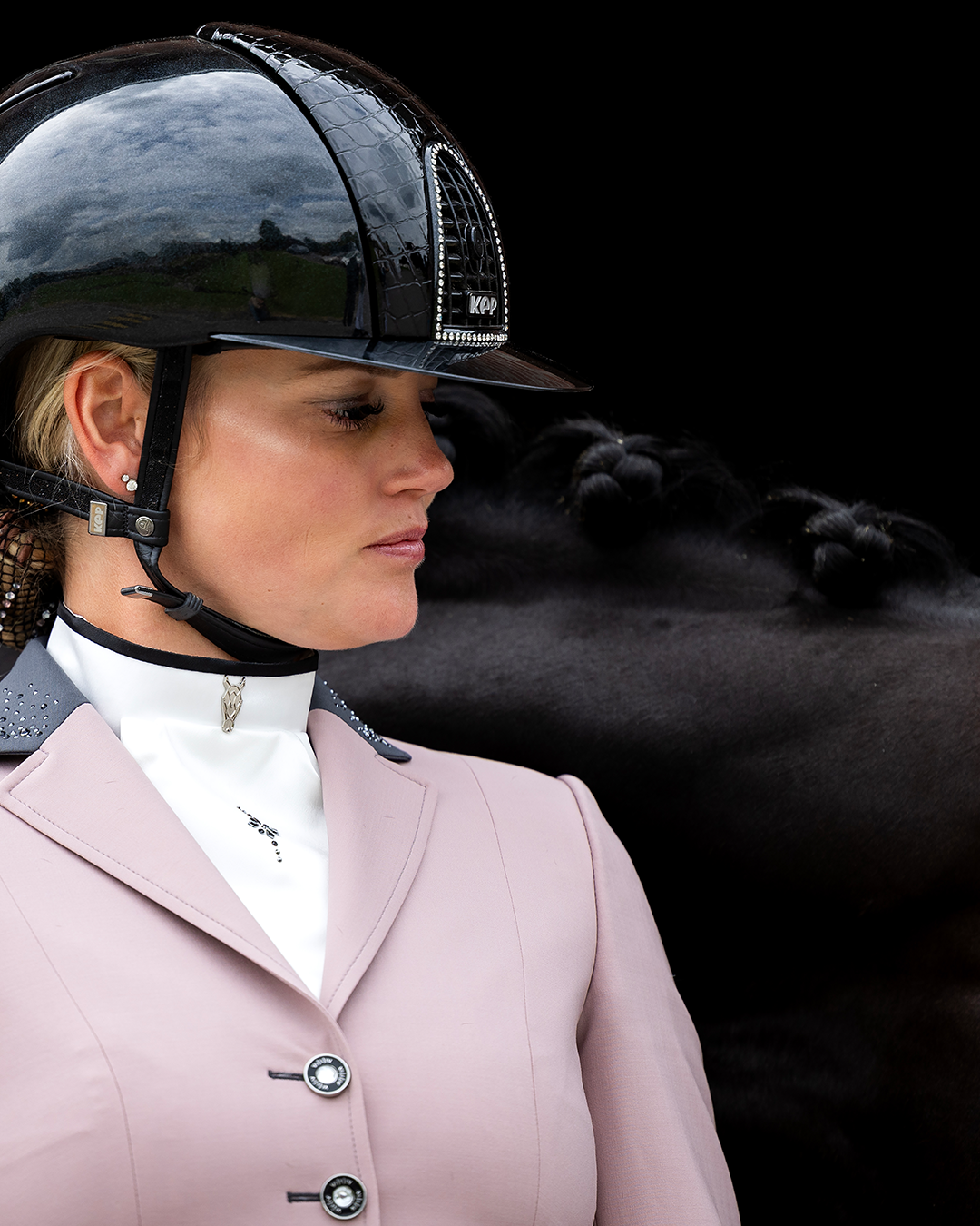 Close-up of model in front of horse wearing JuulC' Pink Powder Ladies Show Jacket with anthracite grey contrasts