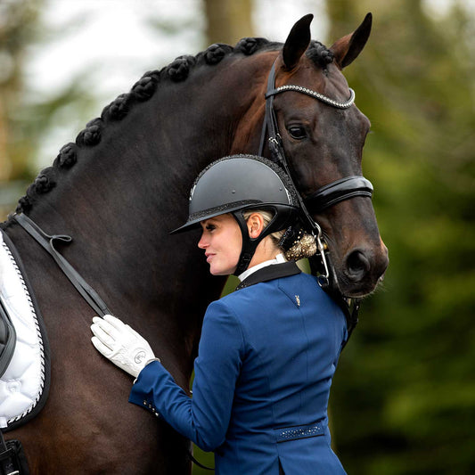 Model hugging her horse wearing JuulC' Royal Blue Women's Show Coat made from sport-tech merino wool 